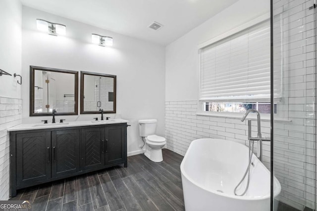 bathroom with toilet, a bathtub, and vanity