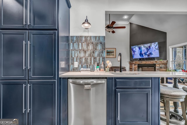 kitchen with sink, ceiling fan, dishwasher, backsplash, and blue cabinets