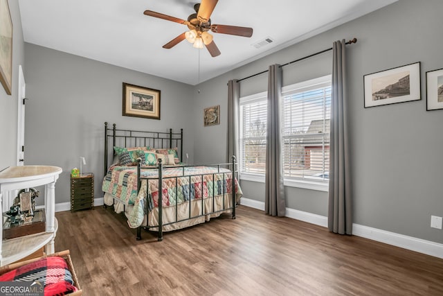 bedroom with dark hardwood / wood-style flooring and ceiling fan