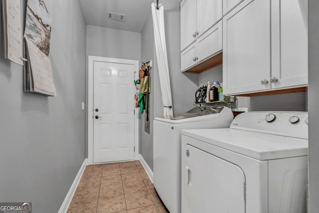 washroom with cabinets, washer and clothes dryer, and light tile patterned floors