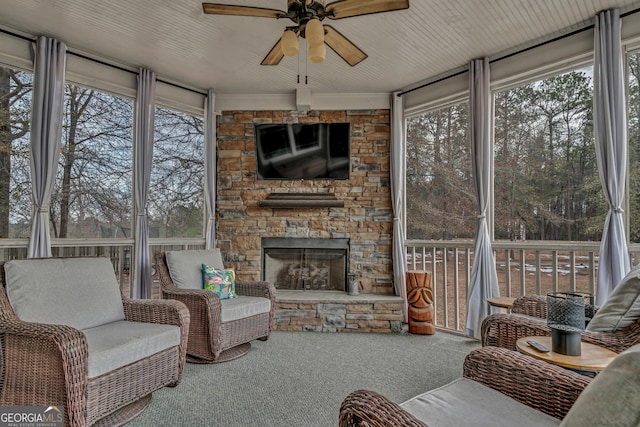 sunroom with ceiling fan, a fireplace, and a healthy amount of sunlight