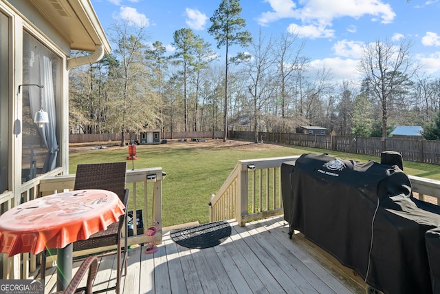 wooden terrace featuring a yard and grilling area