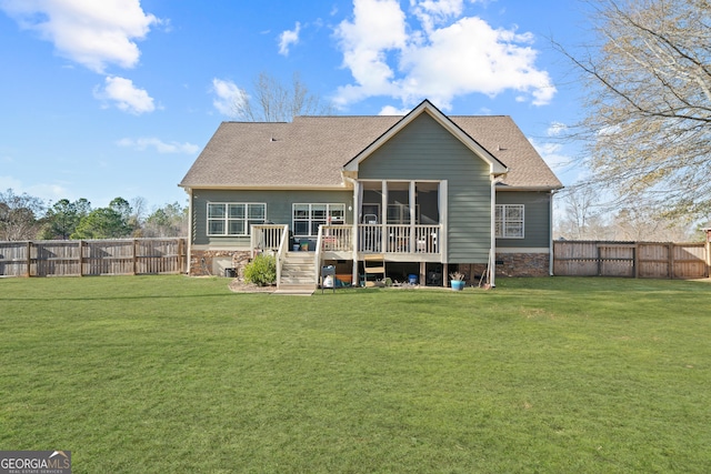 back of property featuring a wooden deck, a sunroom, and a lawn