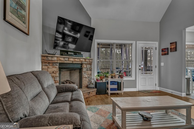 living room with hardwood / wood-style floors, vaulted ceiling, and a fireplace