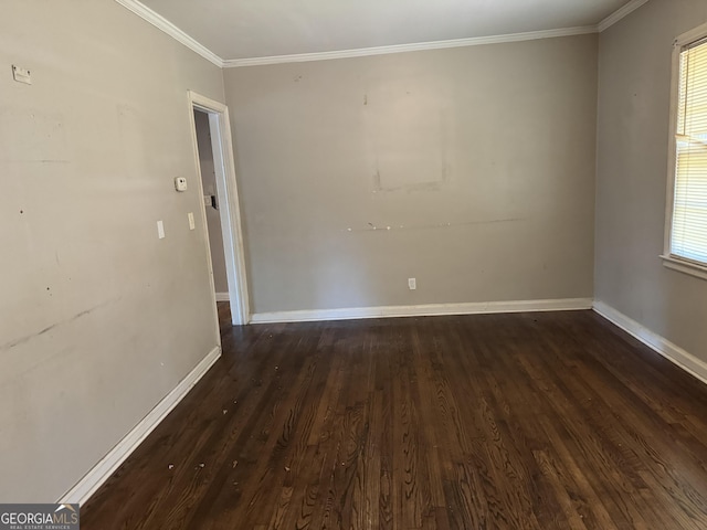 spare room featuring plenty of natural light, dark hardwood / wood-style floors, and ornamental molding