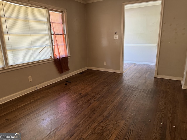 spare room with dark hardwood / wood-style flooring and ornamental molding