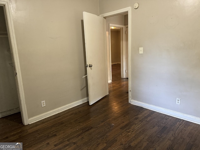 unfurnished bedroom featuring dark wood-type flooring and a closet