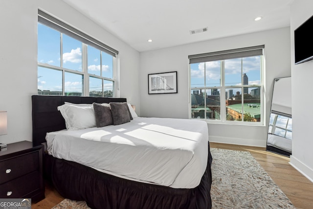 bedroom featuring light wood-style floors, recessed lighting, visible vents, and baseboards