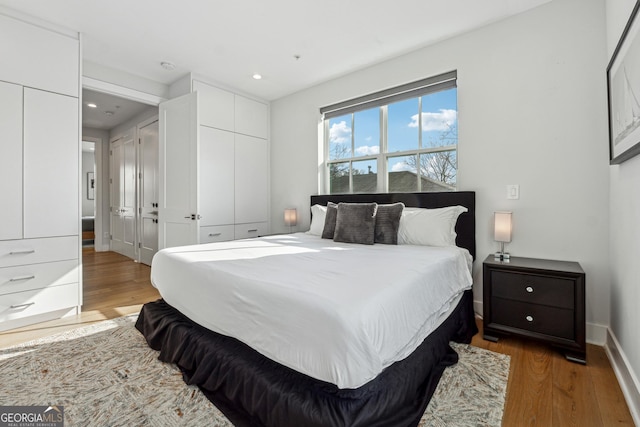 bedroom with dark wood-type flooring, recessed lighting, and baseboards