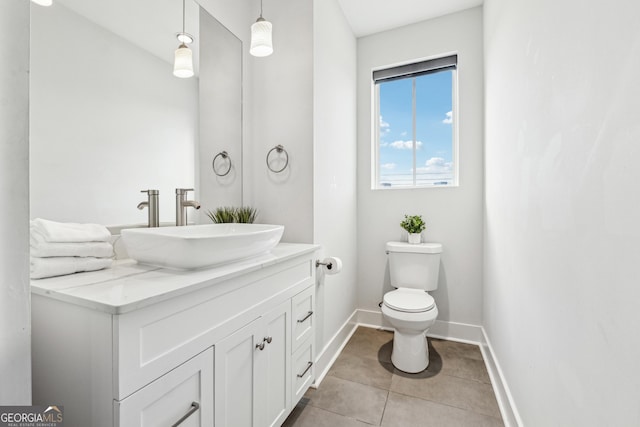 half bath featuring toilet, tile patterned floors, baseboards, and vanity