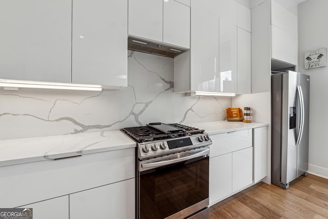 kitchen featuring appliances with stainless steel finishes, modern cabinets, white cabinetry, and under cabinet range hood