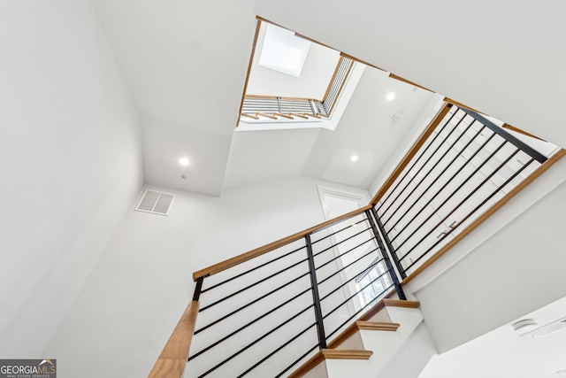 stairs with a skylight, visible vents, and recessed lighting