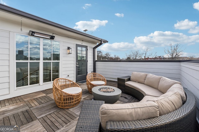 wooden deck with an outdoor living space with a fire pit