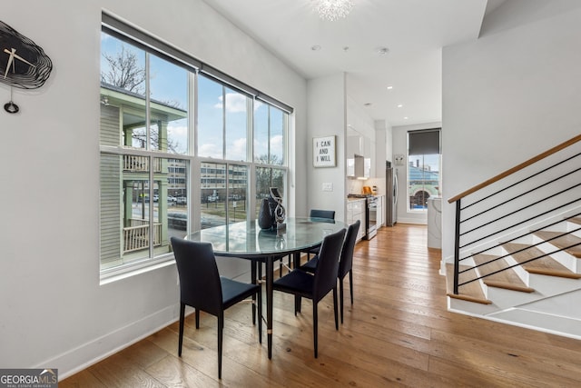 dining space with recessed lighting, baseboards, stairway, and light wood finished floors