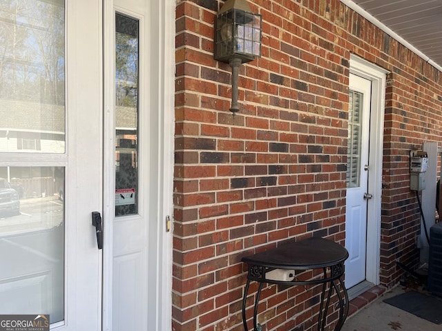 entrance to property featuring brick siding