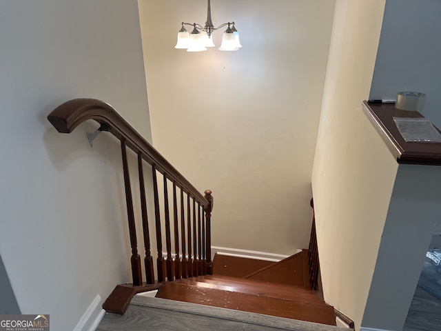 staircase featuring an inviting chandelier