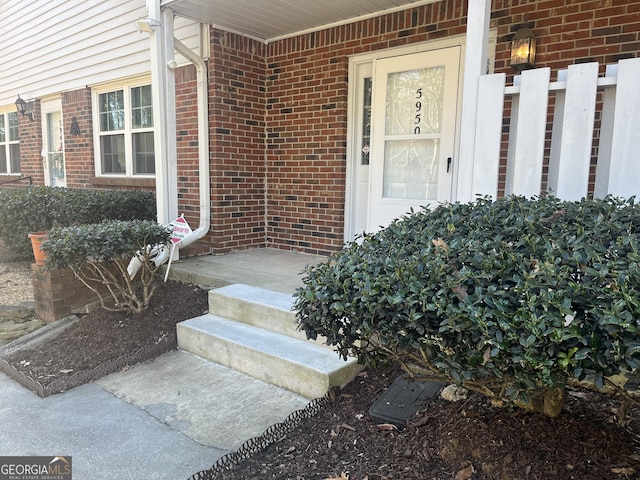 view of exterior entry featuring brick siding