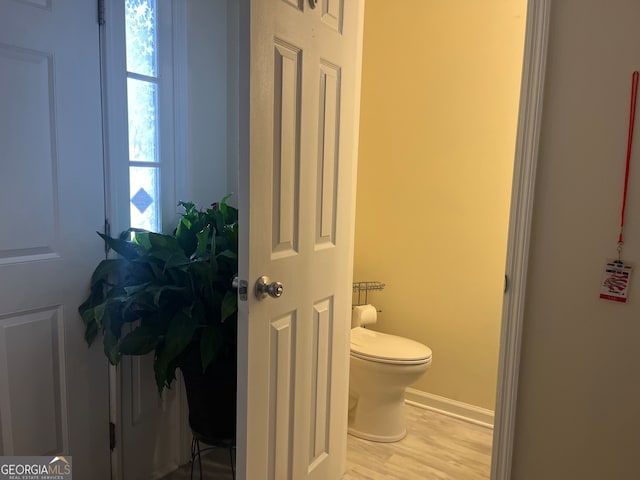 bathroom featuring wood finished floors, toilet, and baseboards