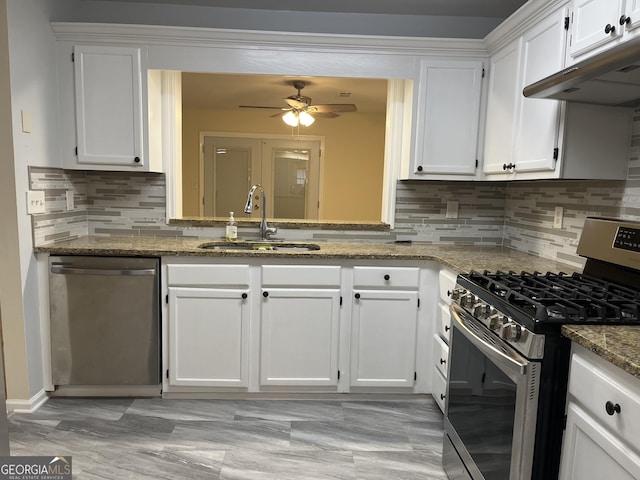 kitchen with under cabinet range hood, appliances with stainless steel finishes, white cabinets, and a sink