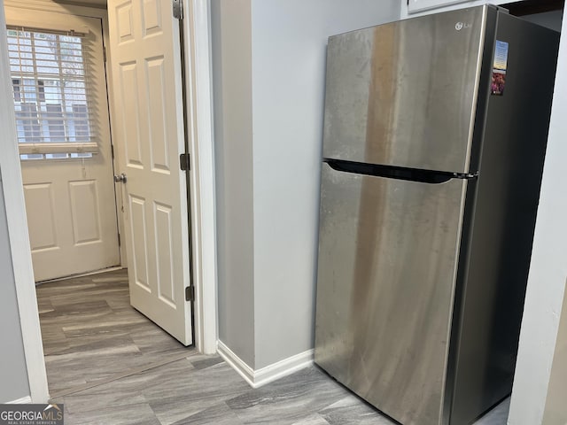 interior space featuring light wood-type flooring and baseboards