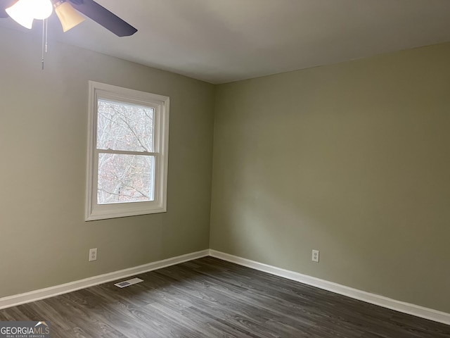 spare room with dark wood-style floors, baseboards, visible vents, and ceiling fan