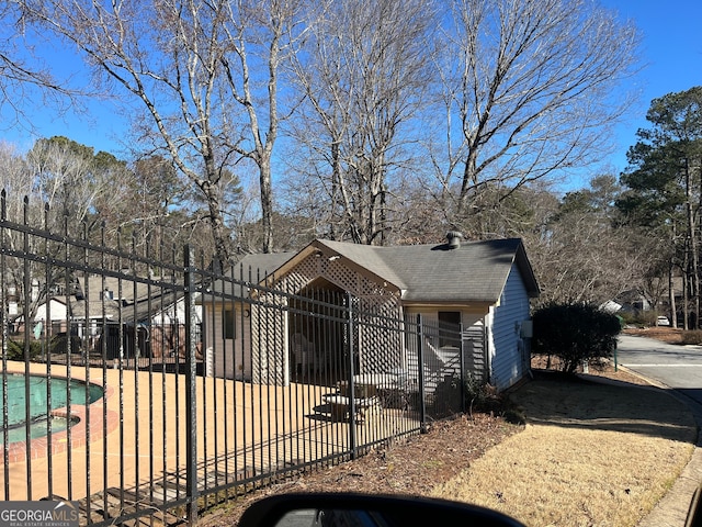 exterior space featuring fence and roof with shingles