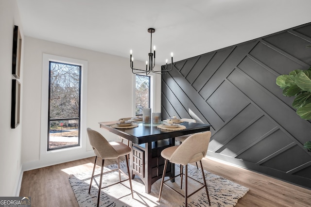 dining space with a notable chandelier and light hardwood / wood-style floors