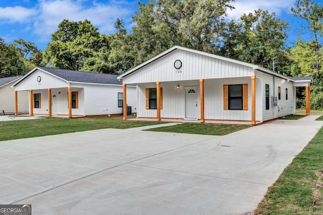 view of front of house with covered porch and a front lawn