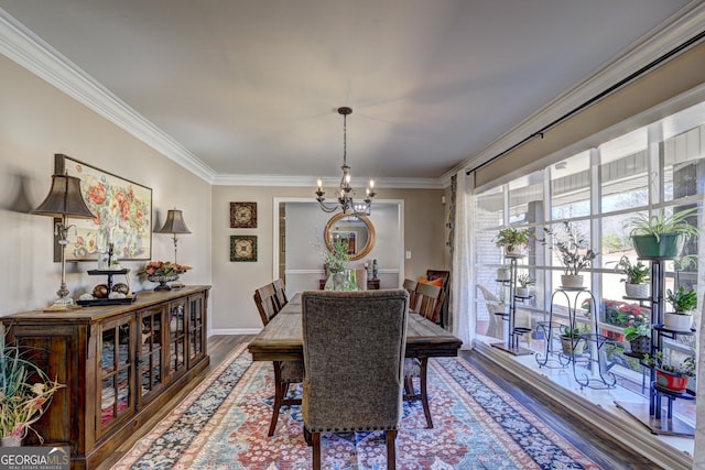 dining room with crown molding, wood-type flooring, and an inviting chandelier