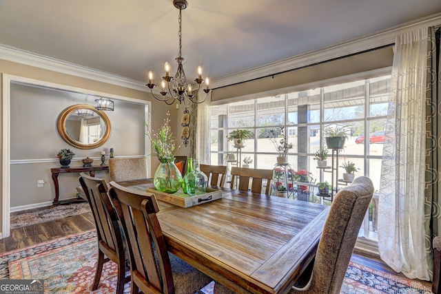 dining area featuring hardwood / wood-style floors, crown molding, and a notable chandelier