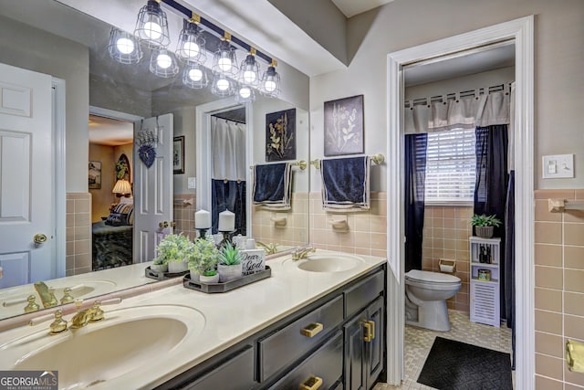 bathroom with toilet, tile walls, tile patterned floors, and vanity