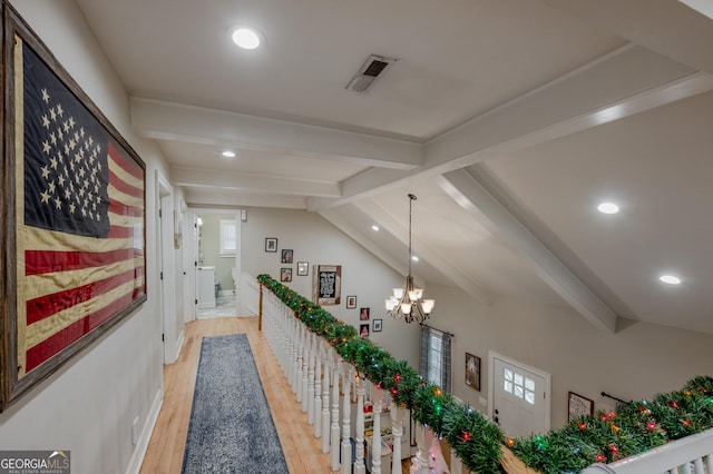 hall featuring plenty of natural light, lofted ceiling with beams, a chandelier, and light wood-type flooring