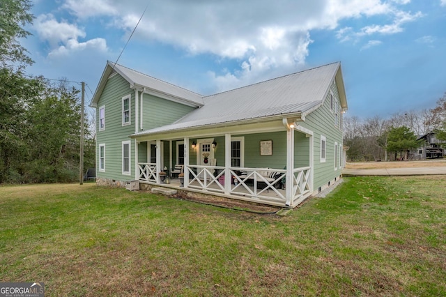 back of house with covered porch and a lawn