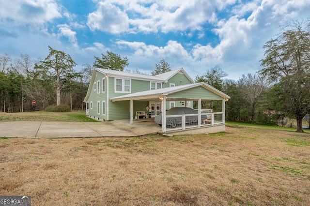 rear view of property with a yard and a carport