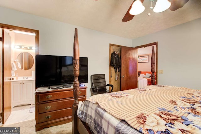 bedroom featuring ensuite bath, light colored carpet, a closet, and ceiling fan