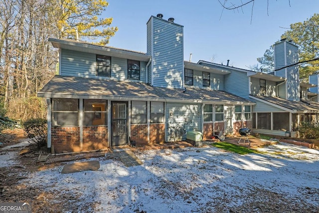 rear view of property featuring a sunroom