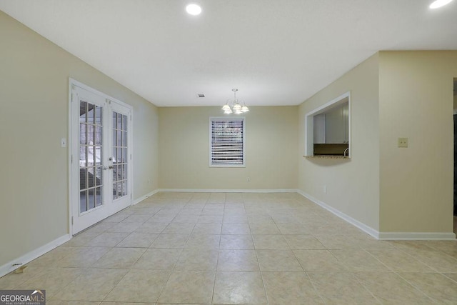 unfurnished room featuring light tile patterned flooring, an inviting chandelier, and french doors