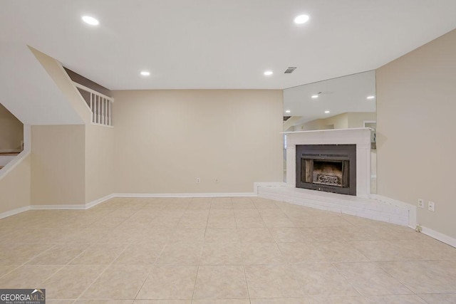 unfurnished living room featuring light tile patterned floors and a fireplace