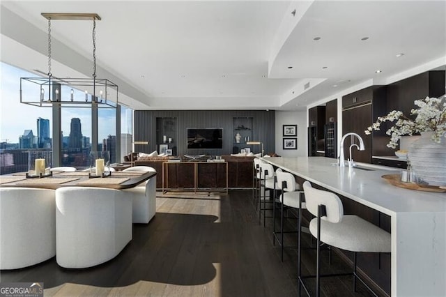 living room with dark wood-type flooring, sink, and an inviting chandelier