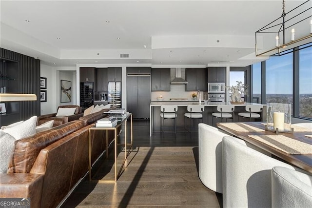 interior space with dark hardwood / wood-style flooring, a chandelier, beverage cooler, and sink