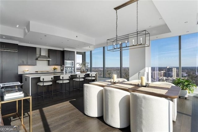 dining area with a wall of windows and dark hardwood / wood-style flooring