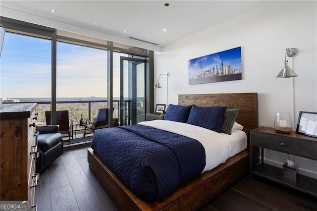 bedroom featuring dark hardwood / wood-style flooring, a wall of windows, and multiple windows