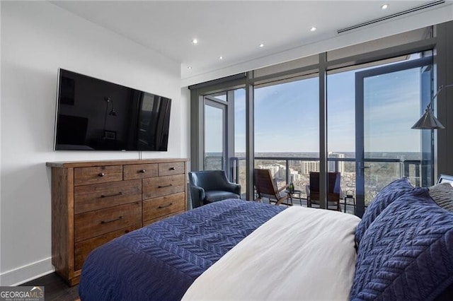 bedroom with floor to ceiling windows and wood-type flooring