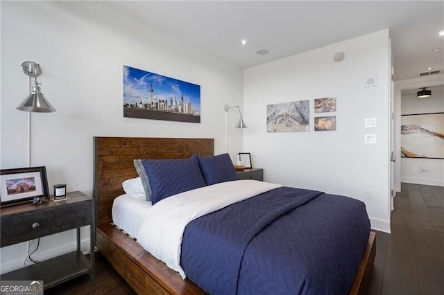 bedroom with dark hardwood / wood-style flooring