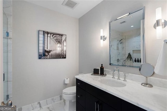 bathroom featuring toilet, vanity, and a shower with door