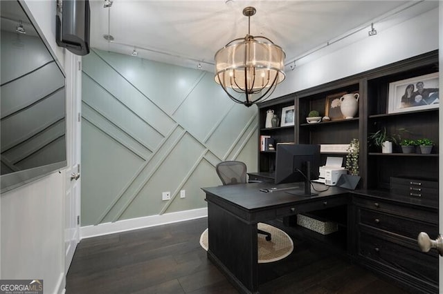 home office with rail lighting, dark wood-type flooring, and a notable chandelier