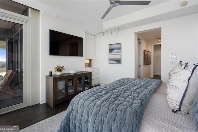 bedroom featuring ceiling fan, dark wood-type flooring, and track lighting