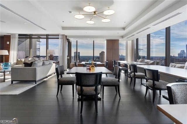 dining area featuring dark hardwood / wood-style floors, a raised ceiling, and a chandelier