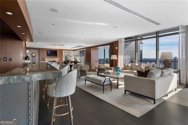 interior space with a wall of windows, wooden walls, and hardwood / wood-style flooring