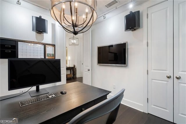 home office with dark hardwood / wood-style flooring and a notable chandelier